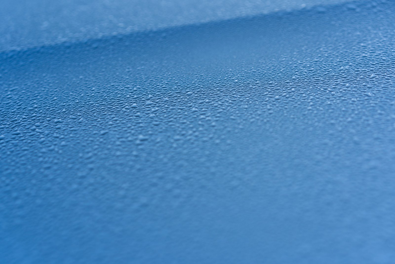 Raindrops on the hood of the car.